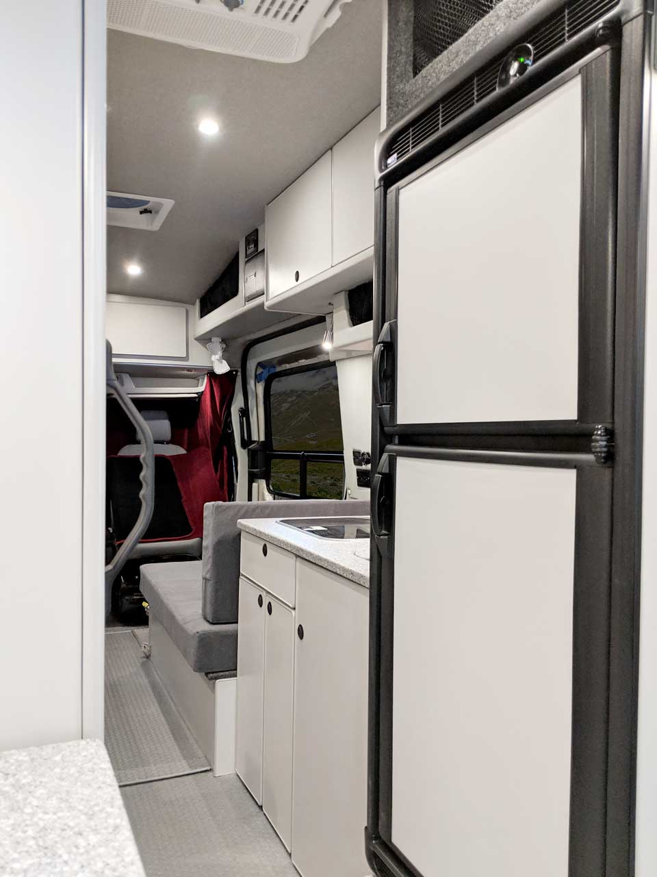 Large upgraded refrigerator in this custom van conversion.