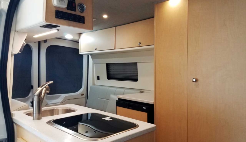 Interior view of refrigerator inside the galley of this van conversion.