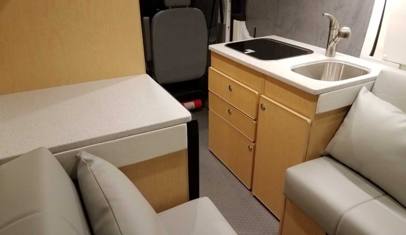 Interior view of refrigerator inside the galley of this van conversion.