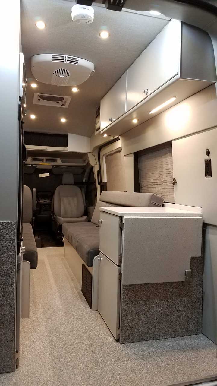 Interior view of a Sportsmobile Transit van conversion with flip up counter extension.