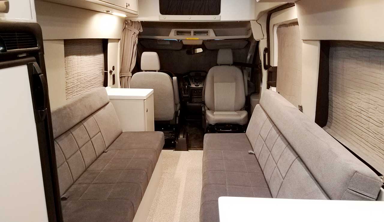 Interior view of a Sportsmobile Transit van conversion with dinette seating.