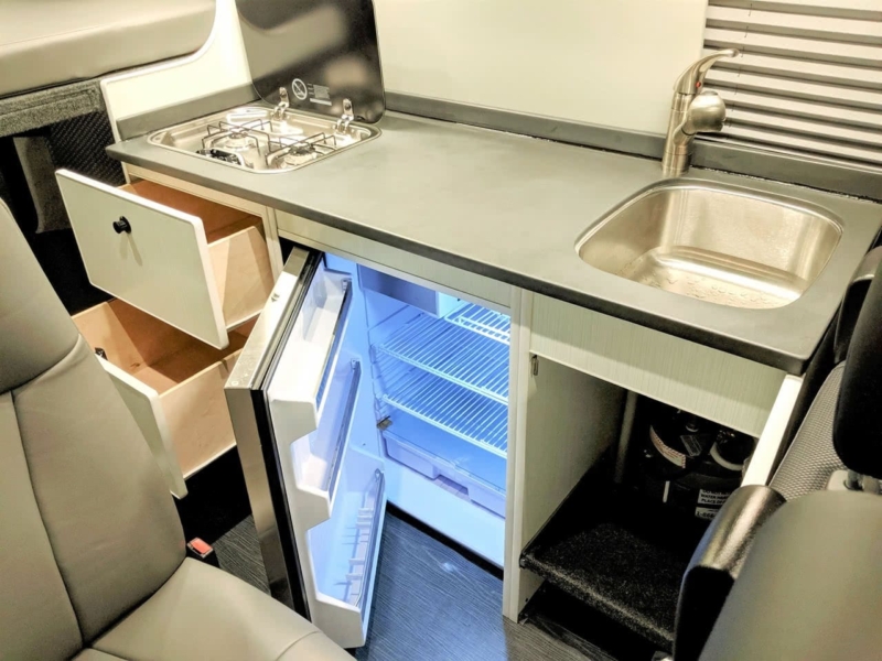 Galley includes a stainless steel refrigerator.