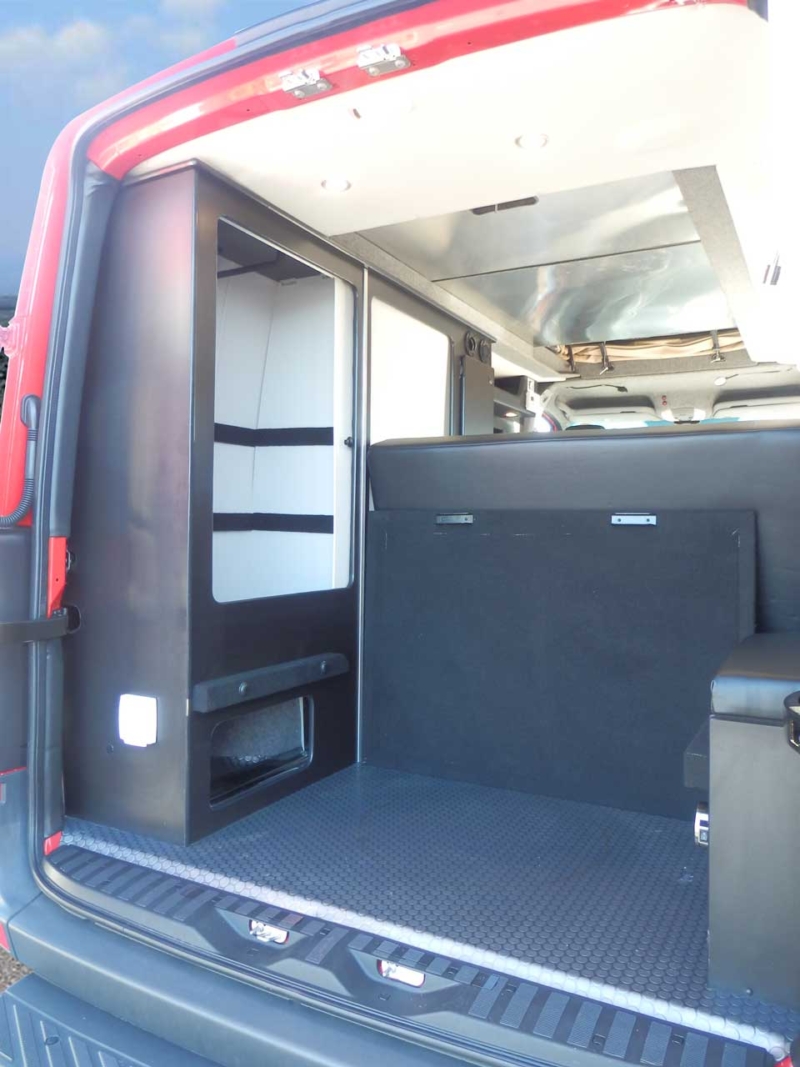 Sportsmobile camper van converison with plenty of storage in the rear.