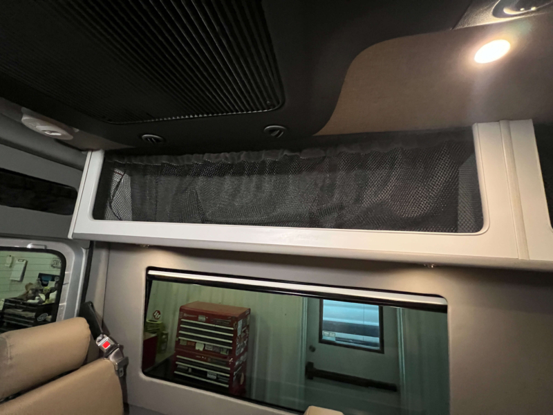 Ample overhead storage compartments in luxury Sprinter 144