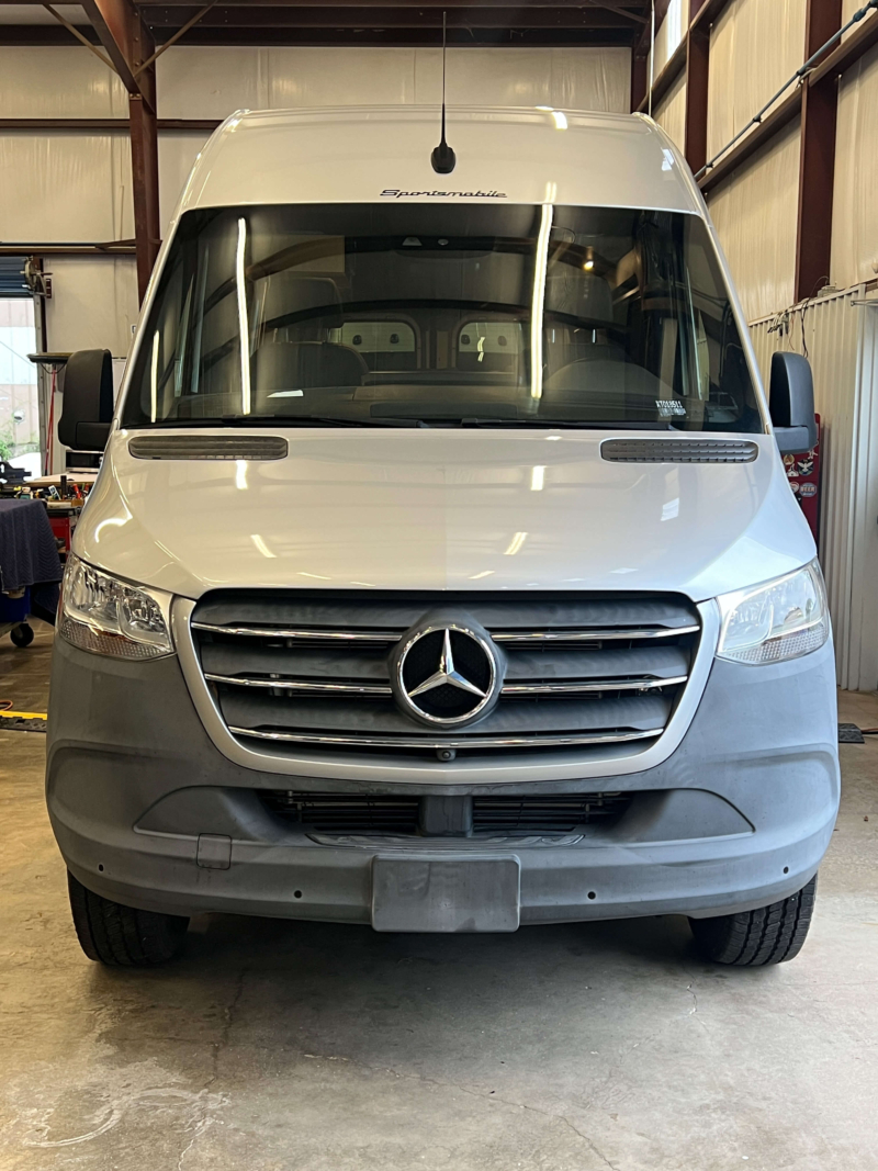 Front view of luxury Mercedes Sprinter van parked inside.