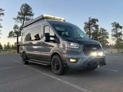 Sportsmobile custom Transit camper van parked at outdoor adventure location