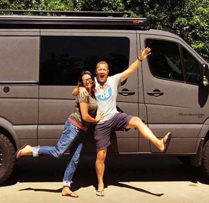 Happy couple in front of their converted van.