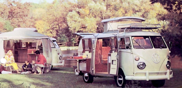 Old picture of people camping next to VW vans.