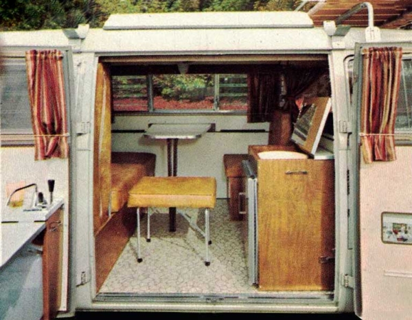 Dining table with seats and a refrigerator inside a van converted by sportsmobile.
