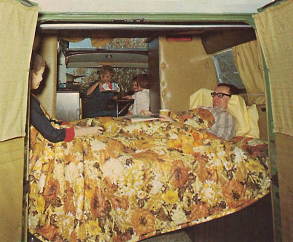 A person sleeping in the bed inside his van.