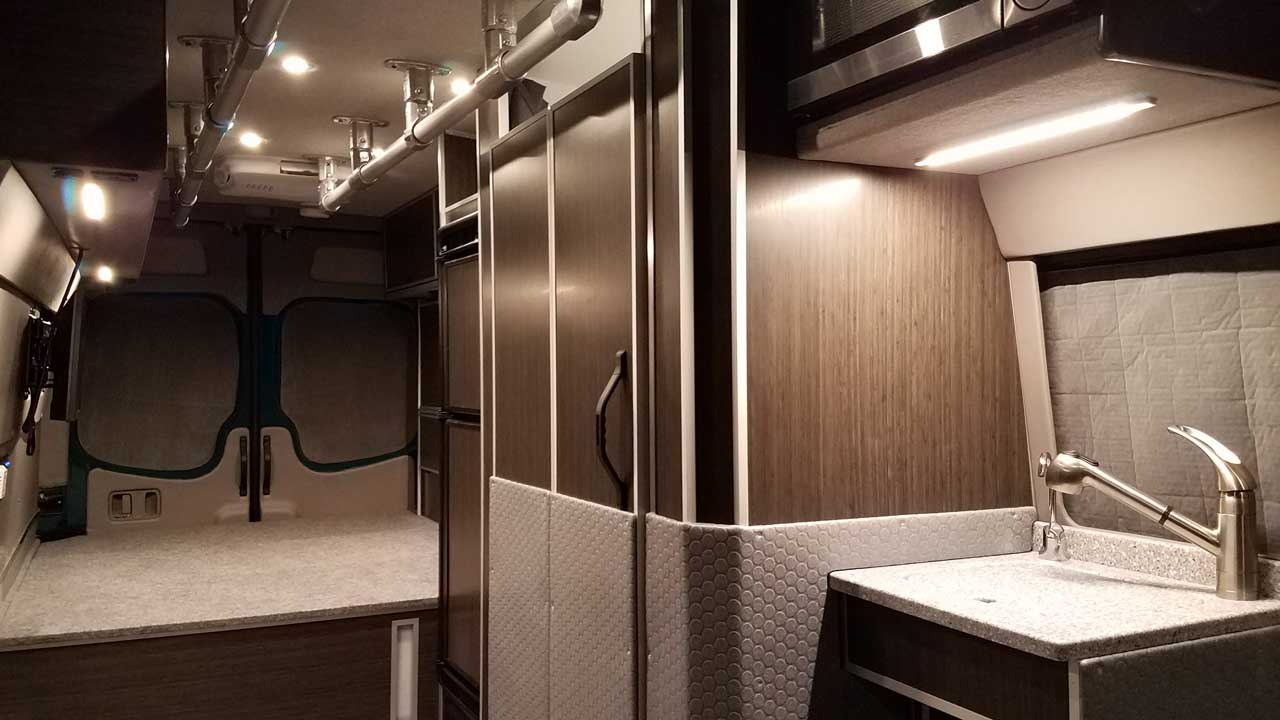 Interior view of a Sportsmobile Sprinter with accessibility rails overhead.